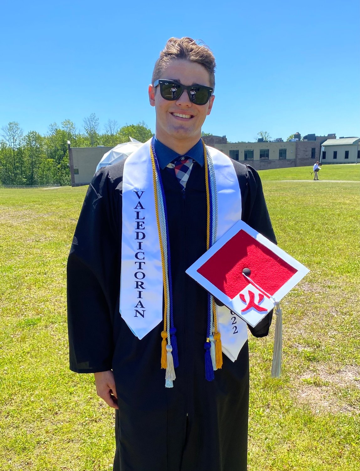 Valedictorian Dylan Sager, holding his decorated cap. He and group of friends took their inspiration from the Japanese anime "Naruto." Sager’s red is appropriately reflective of the show’s Leader of the Village.